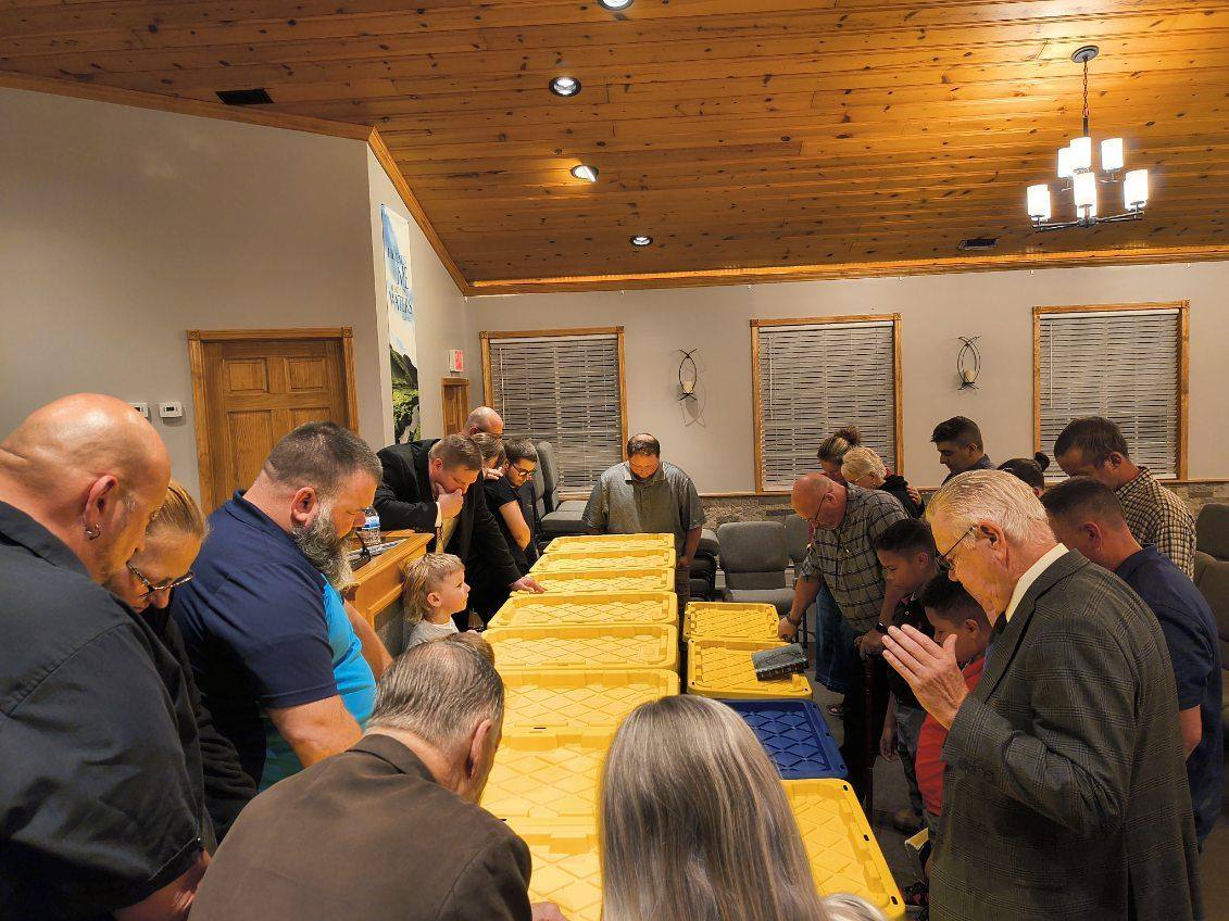 Community prayer over mission supplies